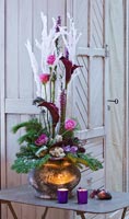 Floral arrangement of Roses, Calla Lilies and conifer foliage in metal pot