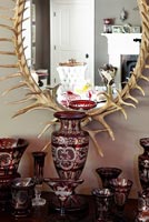 Glassware display under mirror with frame made of antlers