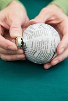 Create a simple Christmas bauble using newspaper -  placing cap back on to bauble