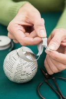 Create a simple Christmas bauble using newspaper - attaching ribbon and tieing a knot
