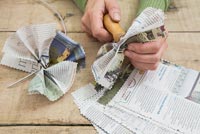 Creating a simple Christmas wreath using newspaper and  wire - making a hole through the newspaper