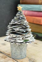 Christmas tree decoration made using layers of newpaper cuttings 