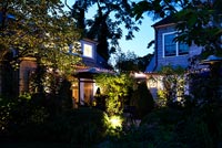 House and garden lit up at night