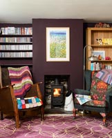 Colourful armchairs by fireplace