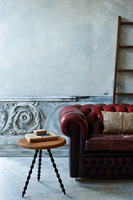Wooden side table and leather chesterfield sofa