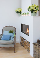 Classic armchair by modern fire with Poinsettias on mantlepiece