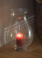 Glass storm lantern with red candle