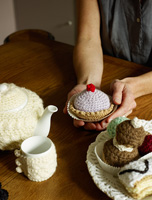 Woman holding knitted cake ornament