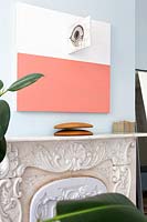 Abstract painting above ornate fireplace
