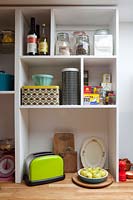 Colourful tins and crockery on kitchen shelves