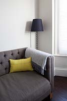Yellow cushion on grey sofa