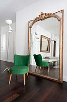 Green chair by vintage mirror
