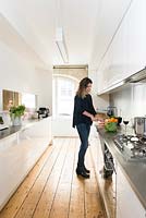 Woman in modern galley kitchen