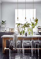 Vases of tropical foliage on dining table