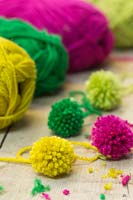 Making christmas pompom decorations - A variety of finished pompoms in different colours 
