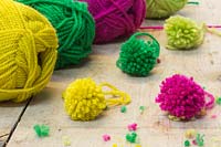 Making christmas pompom decorations - A variety of finished pompoms in different colours 