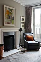 Grey armchair by fireplace