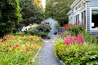 Path through colourful borders with Daylilies and Astilbe flowers