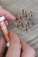 Making copper wire star decorations - Repeat the weaving of the copper wire for roughly 10-12 times, this helps to strengthen the star as well as making the shape more distinctive