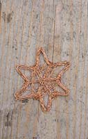 Making copper wire stars - finished decorations on wooden surface