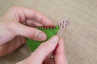 Making stitched felt christmas decorations - Insert the decorative string with a loop and sew this into the felt star. This will be used for hanging the star
