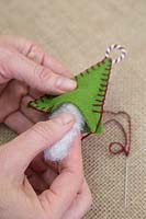 Making stitched felt christmas decorations - Insert the wool stuffing into the felt