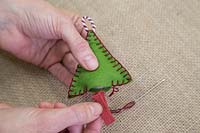 Making stitched felt christmas decorations - Sew a piece of coloured string to the base of the shape