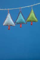 Making stitched felt christmas decorations - miniature christmas trees made from felt and decorative string