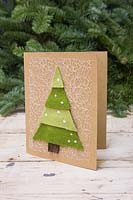 Making felt christmas tree cards - A hand made Christmas card featuring a layered Christmas tree against a white background 