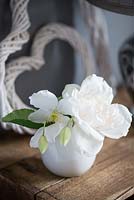 Roses and Clematis flowers in white vase