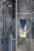 Grey marble shower with storage alcove