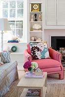 Patterned cushion on pink armchair