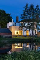 Riverside cottage lit up at night