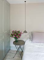 Bedside table with vase of Clematis flowers