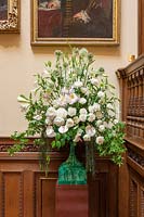 Floral display on oak staircase with Allium 'Mount Everest' and Peony 'Duchesse de Nemours' flowers in malachite vase