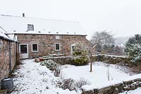 House and garden under snow
