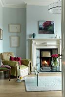 Green armchair by fire