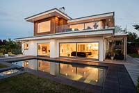 Contemporary house and pool lit up at dusk