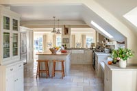 Country style kitchen with limestone worktops and marble floor
