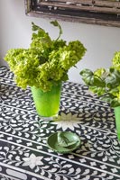 Green glass containers with Viburnum flowers