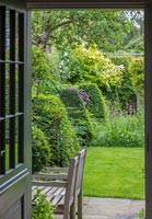 View into garden with clipped Box topiary pyramids