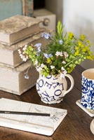 Bunch of Alchemilla and Forget-me-not flowers in patterned jug