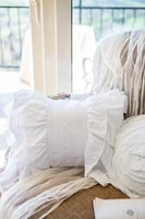 Detail of white lace cushion and accessories