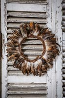 Detail of decorative feather wreath on wooden shutters