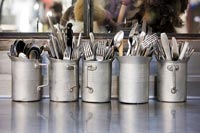 Metal jugs full of cutlery