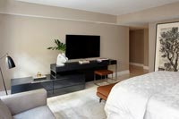 Modern bedroom with large wall mounted television 