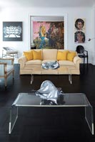 Plexiglass coffee tables in eclectic living room with colourful artwork 