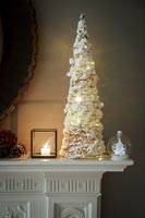 White Christmas tree and decorations on mantelpiece 