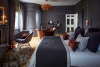 Modern bedroom with dark painted walls and freestanding bath 