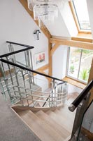 View down modern staircase with exposed wooden beams 